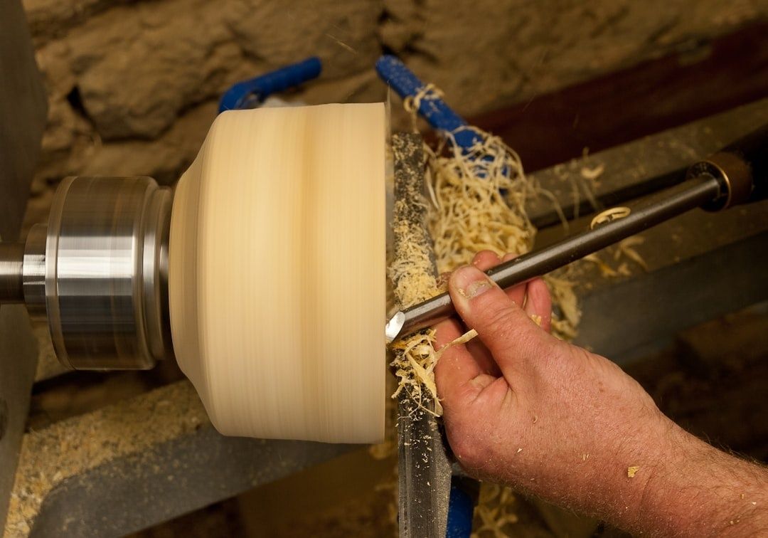 Woodturner uses a gouge to shape a bowl blank on a lathe